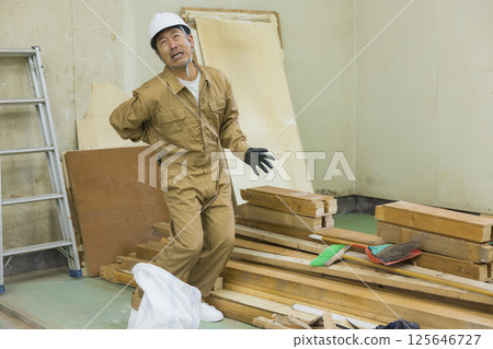 Worker at demolition site suffering from back pain 125646727