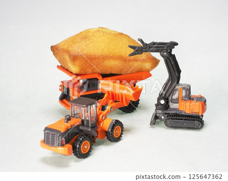 Construction machines crowding around sweets Construction machines crowding around sweets 125647362