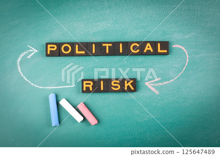 Political Risk Concept with Alphabet Blocks on Chalkboard 125647489