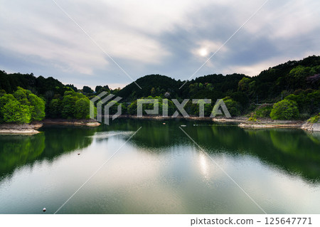 風吹過天空和湖面。湖面上的倒影彷彿在跳舞。在奈良布目水壩。 125647771