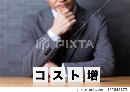 A middle-aged male businessman wearing a suit and worried about cost increases A middle-aged male businessman wearing a suit and worried about cost increases 125648175