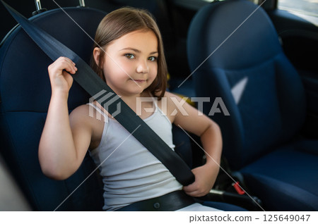 Little girl traveling in car enjoying security during road trip 125649047