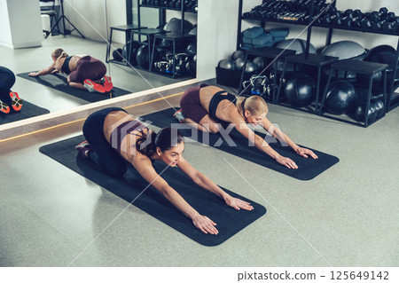 Young women doing stretching on the mats in the gym 125649142