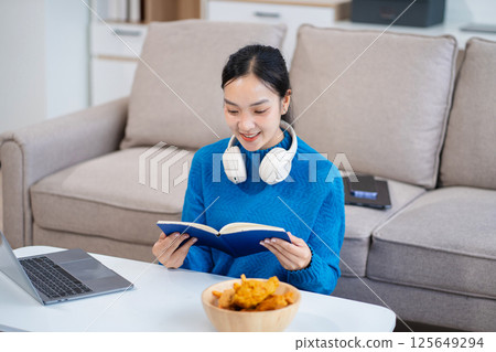 Office worker lifestyle people. Woman writing notes on book and using laptop. home office workplace lifestyle people. 125649294