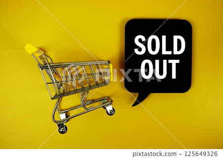 Sold Out text on speech bubble with mini trolley shopping cart top view on yellow background 125649326