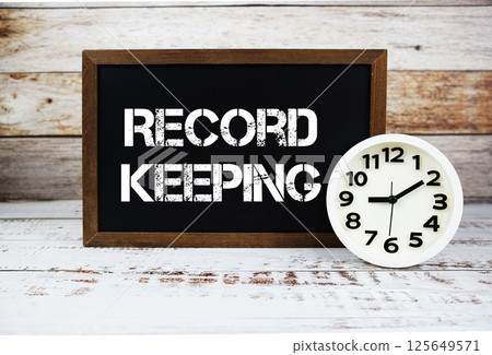 Record Keeping text message and alarm clock on wooden background 125649571