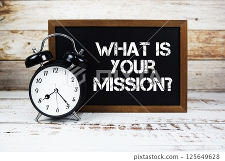 What is Your Mission? text message and alarm clock on wooden background 125649628