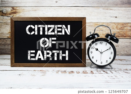 Citizen of Earth text message and alarm clock on wooden background Citizen of Earth text message and alarm clock on wooden background 125649707