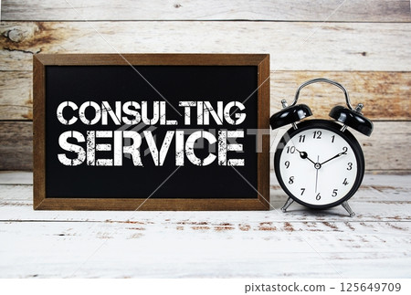 Consulting Service text message and alarm clock on wooden background 125649709