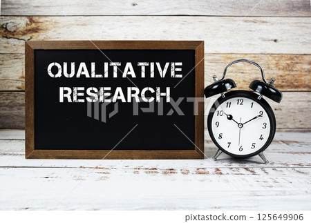 Qualitative Research text message and alarm clock on wooden background Qualitative Research text message and alarm clock on wooden background 125649906