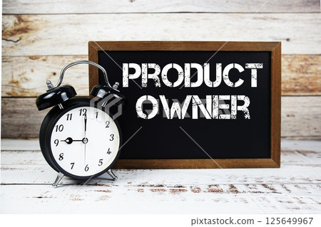 Product Owner text message and alarm clock on wooden background 125649967