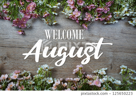 Welcome August text with flowers frame on wooden background 125650223