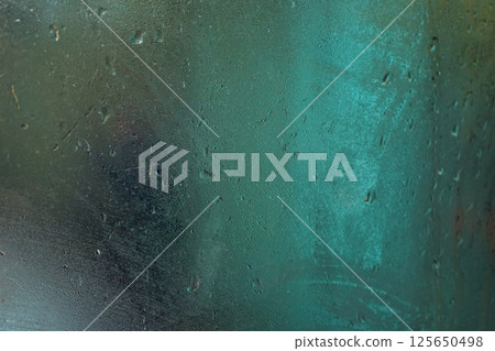 Wet steamy window inside bus on a rainy day, blurred green neon light background Wet steamy window inside bus on a rainy day, blurred green neon light background 125650498