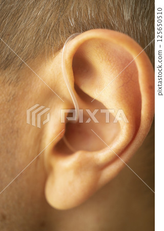 Hearing aid ear of man 125650510