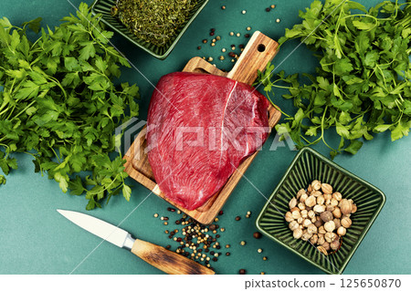 Raw red meat cuts on cutting board. Raw red meat cuts on cutting board. 125650870