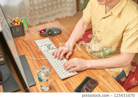 A man working on a computer via telework A man working on a computer via telework 125651070