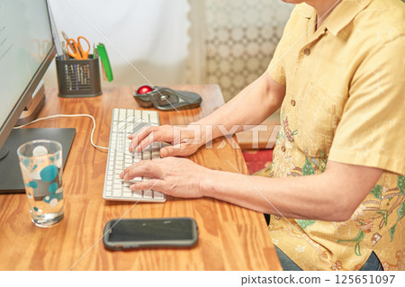 一名男子透過遠距辦公在電腦上工作 一名男子透過遠距辦公在電腦上工作 125651097