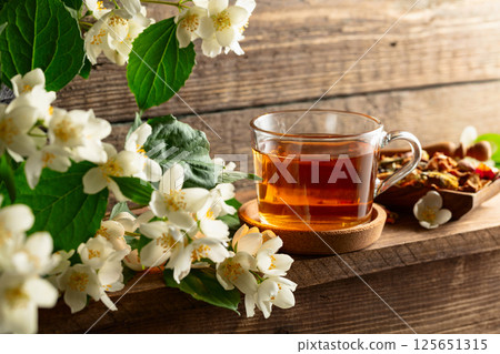 Cup of jasmine tea and fresh jasmine flowers. Cup of jasmine tea and fresh jasmine flowers. 125651315