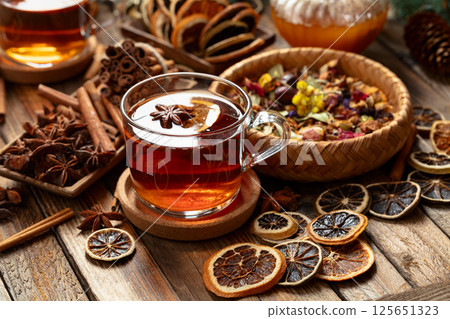 Herbal tea with cinnamon, anise, dried herbs, and dry citrus slices. Herbal tea with cinnamon, anise, dried herbs, and dry citrus slices. 125651323