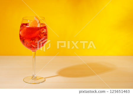 A cocktail arranged on a table against a light yellow background 125651463