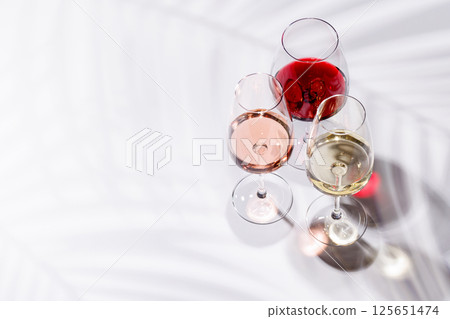 Three wine glasses filled with red, white, and rose wine Three wine glasses filled with red, white, and rose wine 125651474