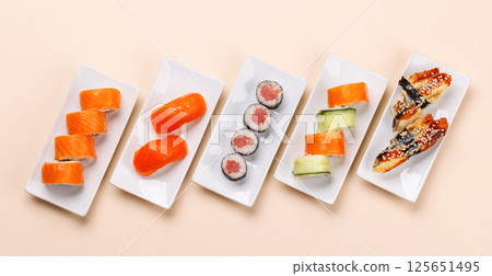 Assorted sushi and maki rolls beautifully arranged on plates 125651495
