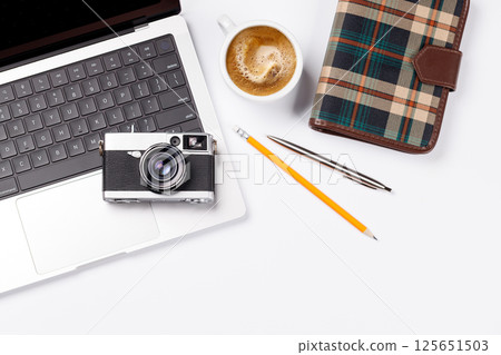 A clean and minimal desk setup featuring a laptop and a coffee cup A clean and minimal desk setup featuring a laptop and a coffee cup 125651503