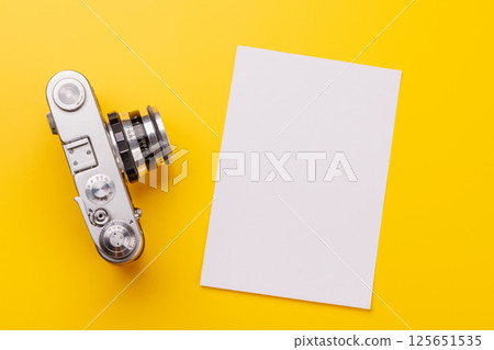Travel-themed flat lay with blank photo card, camera 125651535