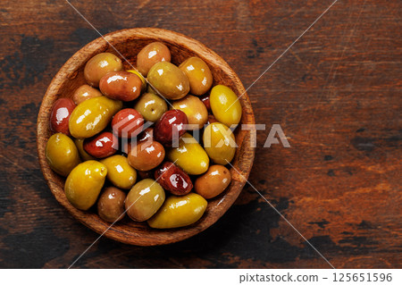 An assortment of various olives presented in a bowl, showcasing different colors, textures, and flavors An assortment of various olives presented in a bowl, showcasing different colors, textures, and flavors 125651596