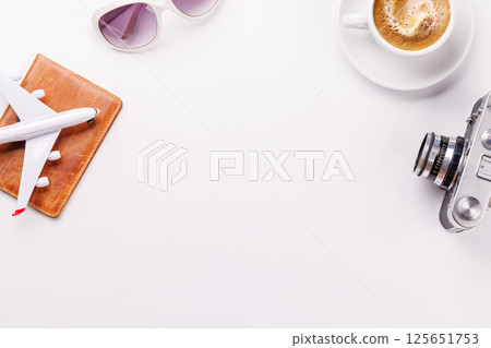 Travel-themed flat lay with toy airplane, camera, and coffee 125651753