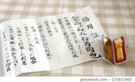 IOU and stamp on kitchen table_Blurred IOU and stamp on kitchen table_Blurred 125651905