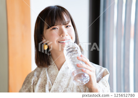 一位身穿浴衣的年輕女子正在補水 125652780