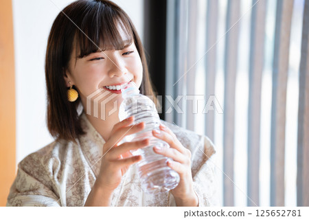 一位身穿浴衣的年輕女子正在補水 125652781