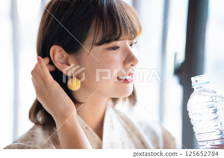 A young woman wearing a yukata hydrating 125652784