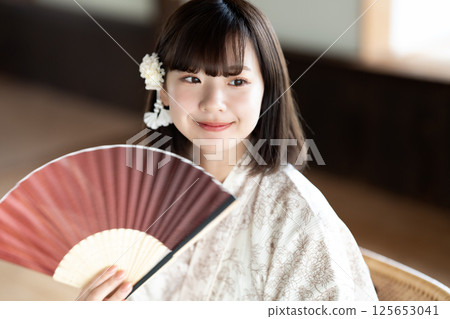 一位身穿浴衣的年輕女子拿著折扇乘涼 125653041