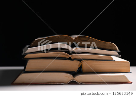 Old library, an open Bible lay on the table, its holy pages of scripture illuminated in the dark room. bible, holy, dark, old, open, library, pages, scripture, table, book, page. 125653149
