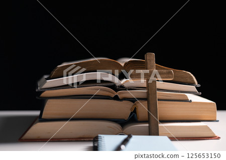 Old library, an open Bible lay on the table, its holy pages of scripture illuminated in the dark room. bible, holy, dark, old, open, library, pages, scripture, table, book, page. 125653150