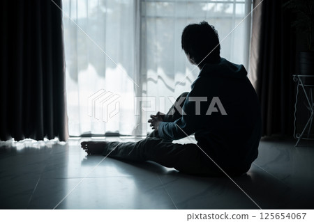 Silhouette of lost cast long shadow, embodying deep despair and hopelessness left him feeling perpetually stressed, sad, and unhappy. man sat alone, feeling weight of anxiety, stress, and depression. Silhouette of lost cast long shadow, embodying deep despair and hopelessness left him feeling perpetually stressed, sad, and unhappy. man sat alone, feeling weight of anxiety, stress, and depression. 125654067