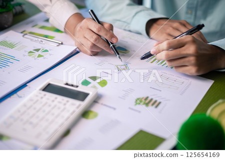 Analyzing green building performance metrics during business meeting. data analysis, green building, business meeting, sustainability, performance metrics, charts, graphs, real estate, eco-friendly. 125654169