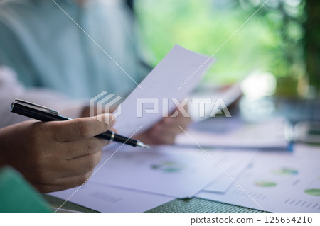 Analyzing green building performance metrics during business meeting. data analysis, green building, business meeting, sustainability, performance metrics, charts, graphs, real estate, eco-friendly. 125654210