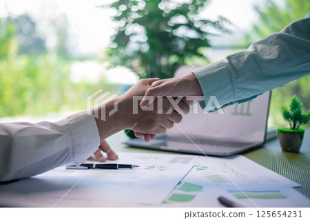 In office, a business meeting was underway, where a man and a woman, along with their team, discussed finance and strategic concepts, working hand in hand to achieve success for their people. In office, a business meeting was underway, where a man and a woman, along with their team, discussed finance and strategic concepts, working hand in hand to achieve success for their people. 125654231