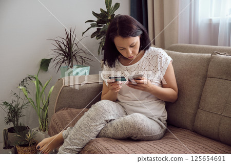 Hands holding credit card and using smartphone. Online shopping Hands holding credit card and using smartphone. Online shopping 125654691