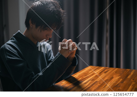 Person raised their hand in prayer at the church, embodying their Christian faith and belief in God, seeking hope and the holy presence of Christ through their devout religion. jesus christ, pray. 125654777