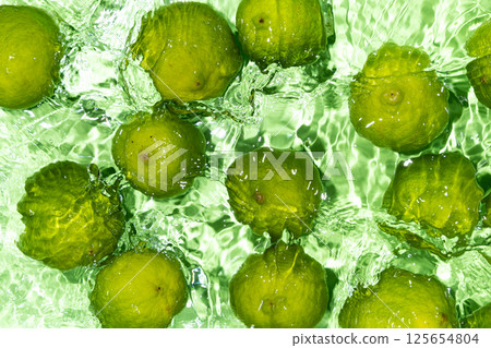 Vibrant Limes Submerged in Water Surface Scene Vibrant Limes Submerged in Water Surface Scene 125654804