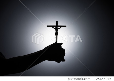 Praying hands holding a cross, Close up holding cross, pray for god in the dark, religious Christian symbol with copy space background. God and Spiritual Concepts. 125655076