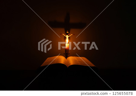 Light candle with holy bible and cross or crucifix on old wooden background in church.Candlelight and open book on vintage wood table christianity study and reading in home.Concept of christ religion 125655078