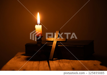 Light candle with holy bible and cross or crucifix on old wooden background in church.Candlelight and open book on vintage wood table christianity study and reading in home.Concept of christ religion Light candle with holy bible and cross or crucifix on old wooden background in church.Candlelight and open book on vintage wood table christianity study and reading in home.Concept of christ religion 125655085