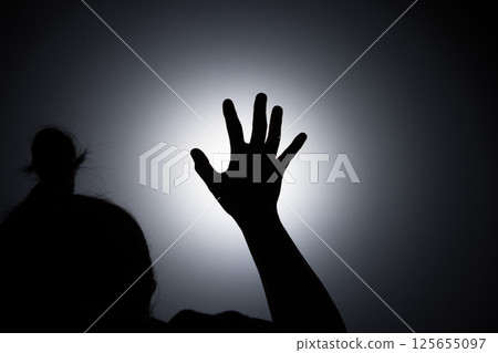 Silhouette photo, A young woman prayed for God's blessings with the power and holiness of God on white background. God and Spiritual Concepts. 125655097
