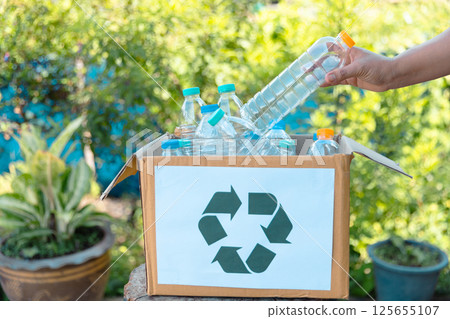 Plastic bottle waste for recycling, reuse concept. Volunteers store plastic bottles in cardboard boxes at a park. Disposal, recycling and waste management. Good conscience. 125655107