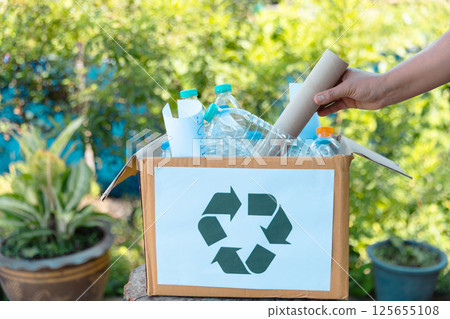 Plastic bottle waste for recycling, reuse concept. Volunteers store plastic bottles in cardboard boxes at a park. Disposal, recycling and waste management. Good conscience. 125655108